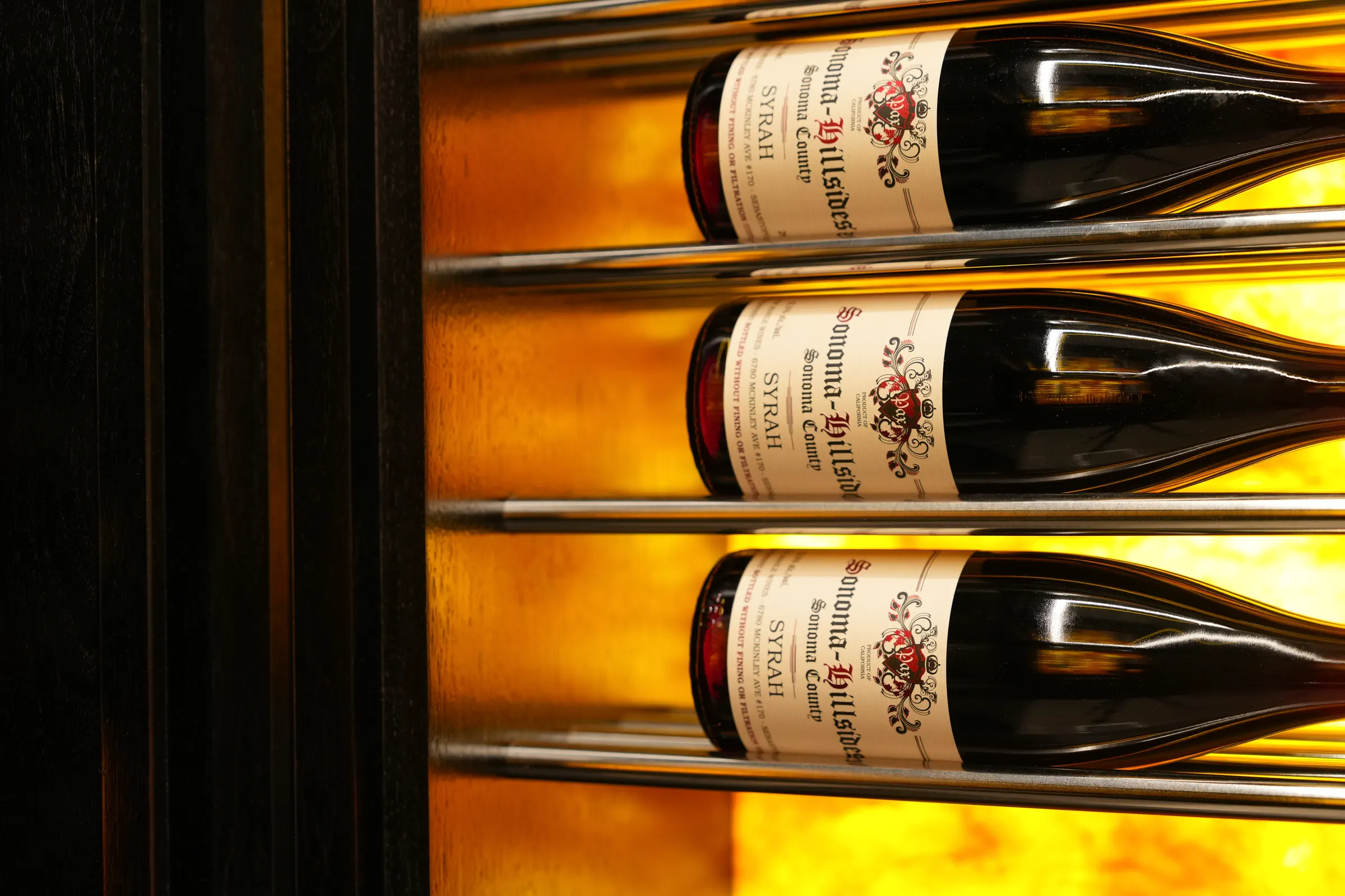 Bottles on backlit shelves in the wine room