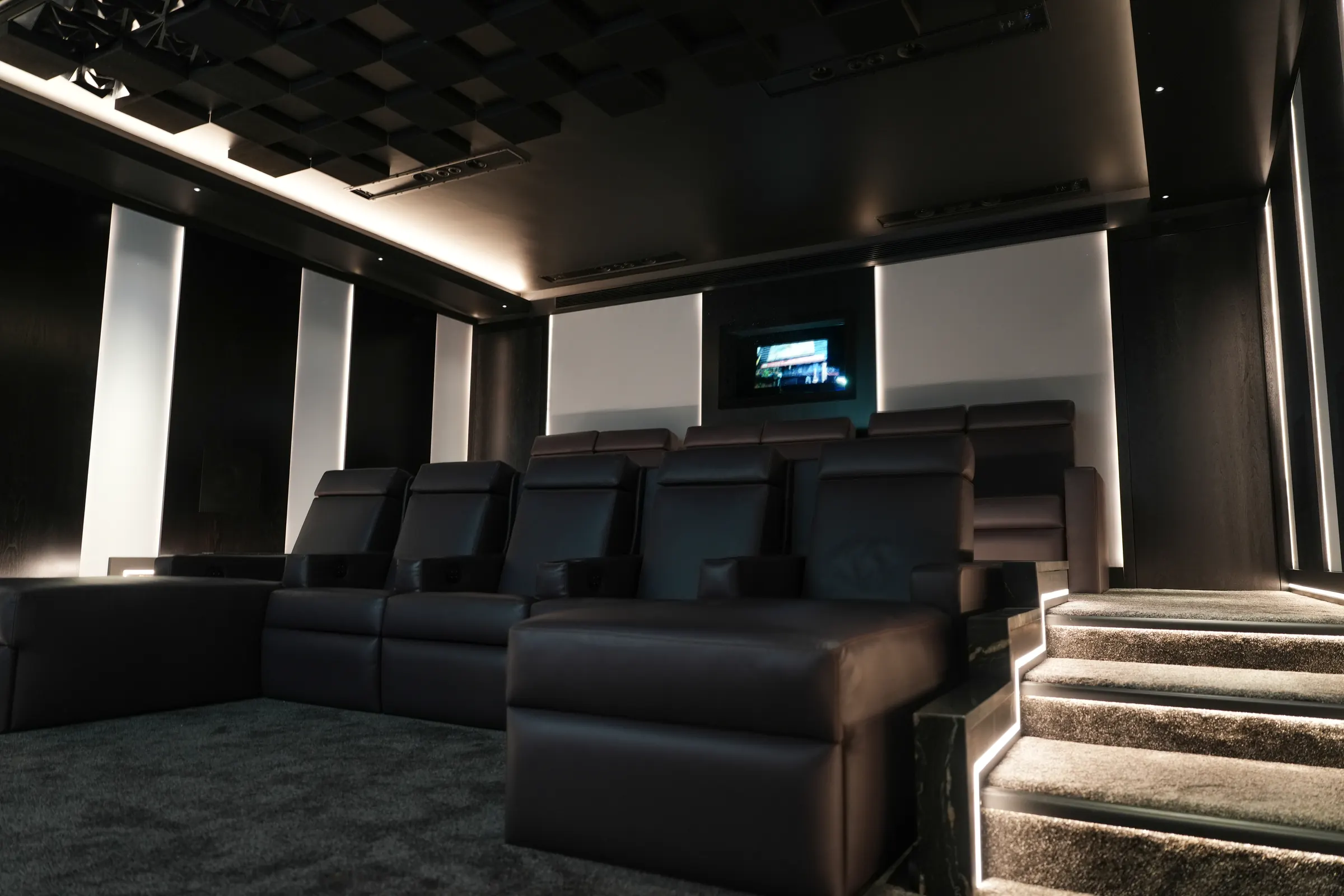 The private cinema: leather recliners, backlit fabric panels and a sculpted acoustic ceiling