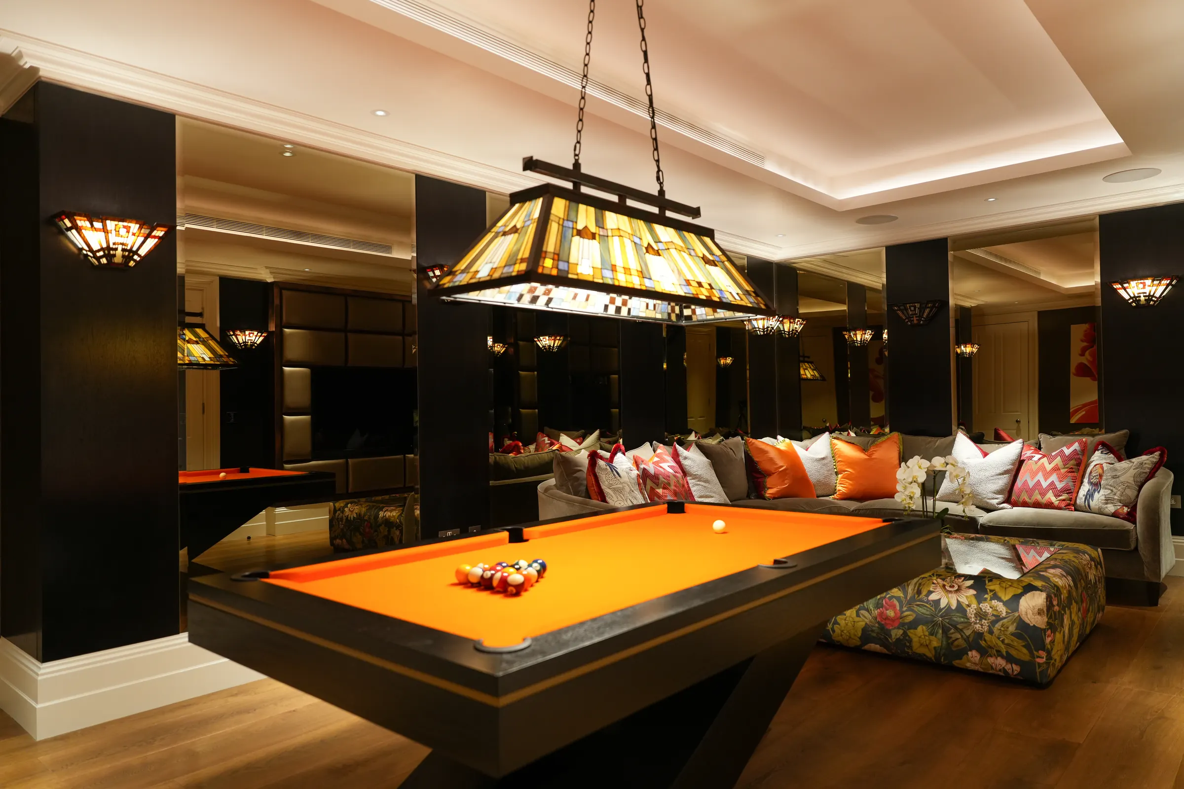 The games room with a pool table under a stained-glass pendant