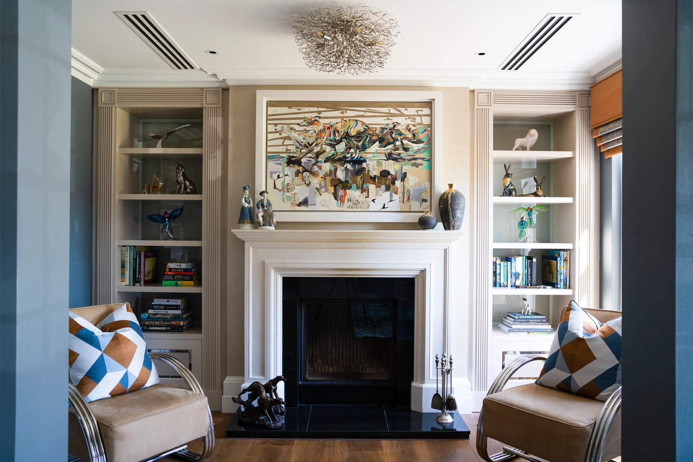 The study, with backlit display cabinets either side of the fireplace
