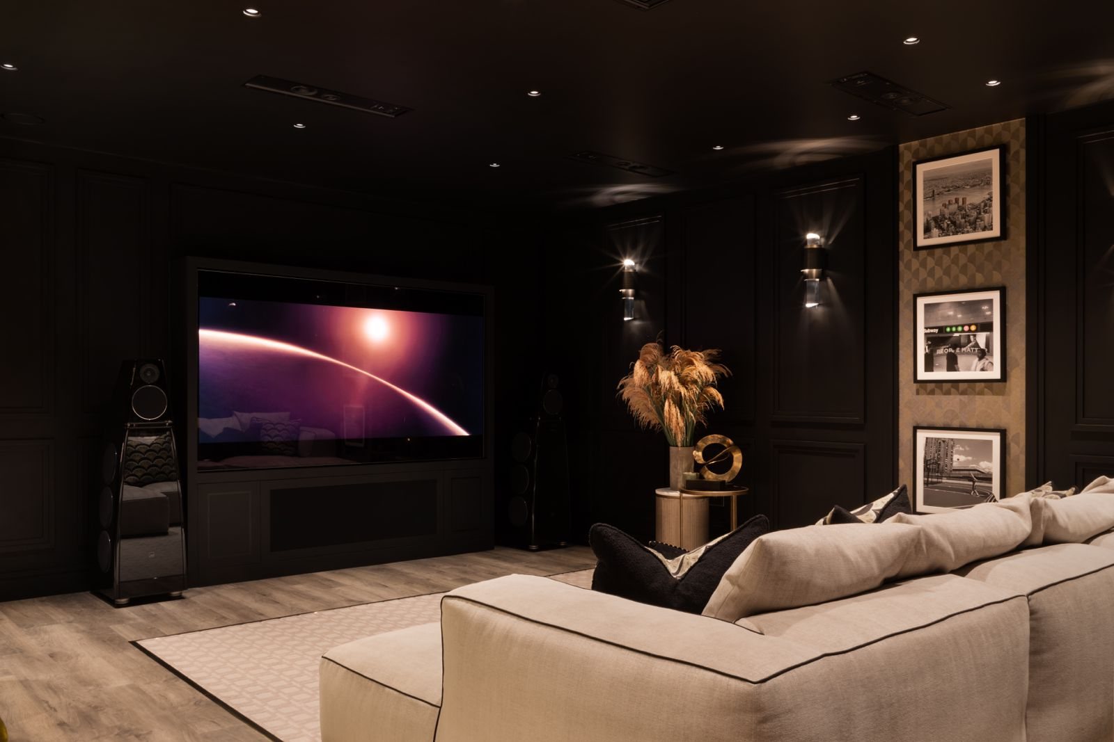 The media wall with a large screen and floorstanding loudspeakers